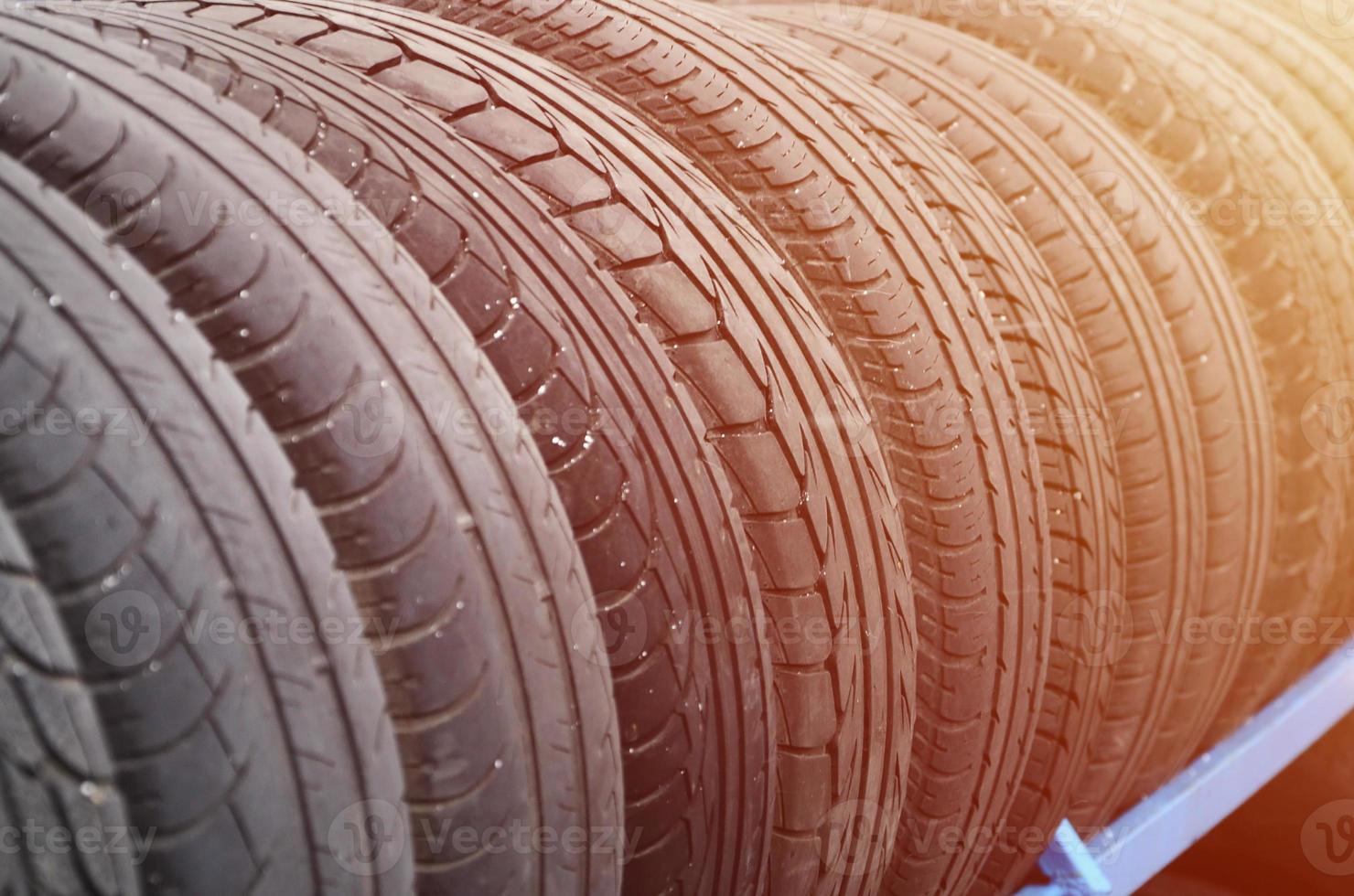 rack avec une variété de pneus de voiture dans un magasin automobile. beaucoup de pneus noirs. fond de pile de pneus. mise au point sélective photo