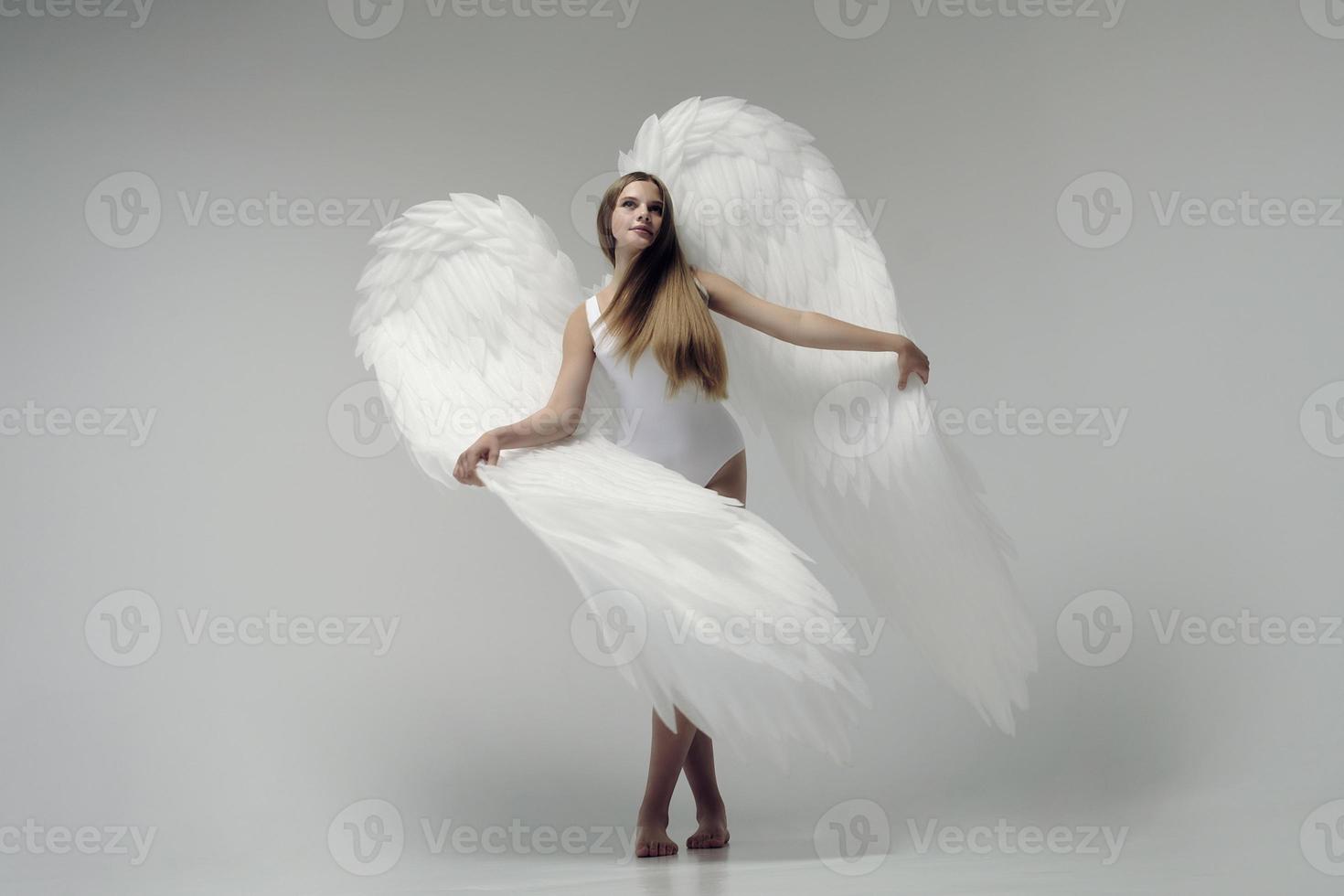 une fille ange romantique dans un body blanc avec des ailes blanches photo