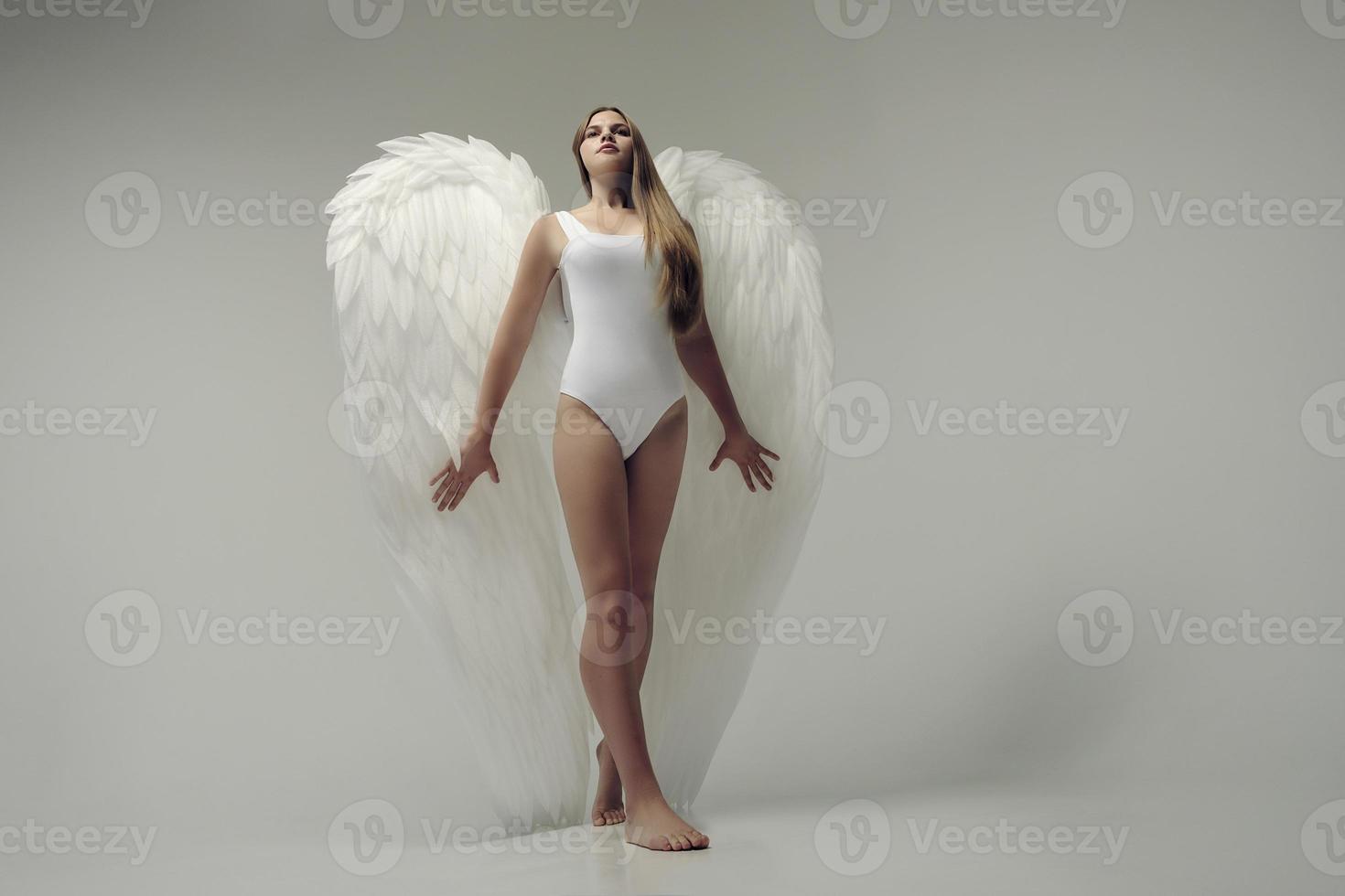 une fille ange romantique dans un body blanc avec des ailes blanches photo