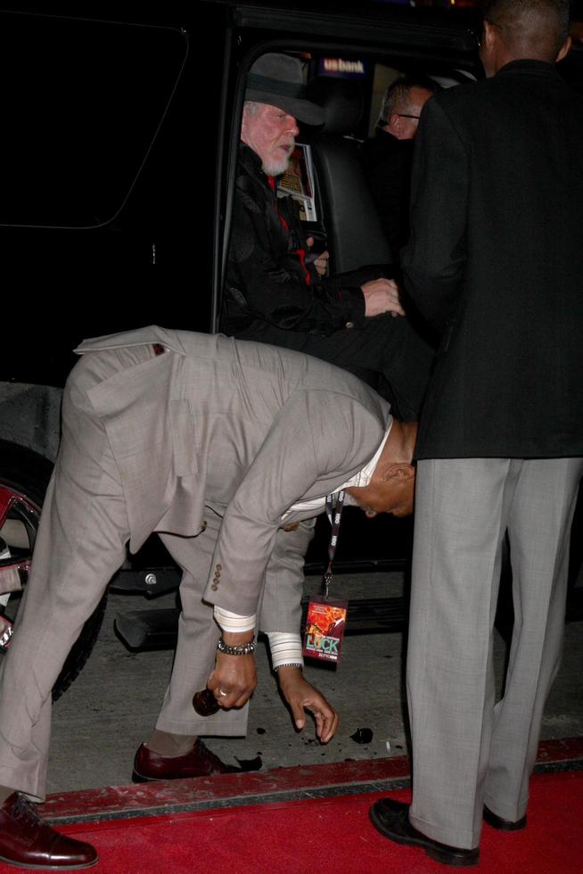 los angeles, 23 janvier - nick nolte, avec oscar williams ramassant une bouteille de bière tombée de la voiture lorsque la porte a été ouverte arrive à la chance los angeles première de la série hbo au graumans chinese theatre le 23 janvier 2012 à los angeles, ca photo