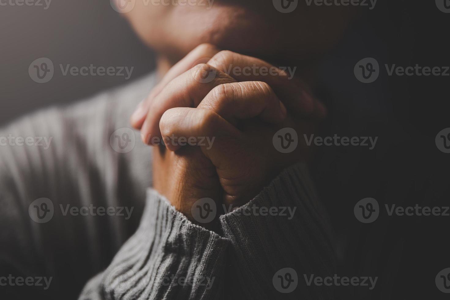 la religion du christ et le christianisme adorent ou prient le concept. une femme catholique chrétienne prie Dieu dans le noir à l'église. main de personne de prière sur fond noir. fille croit et foi en jésus christ. photo