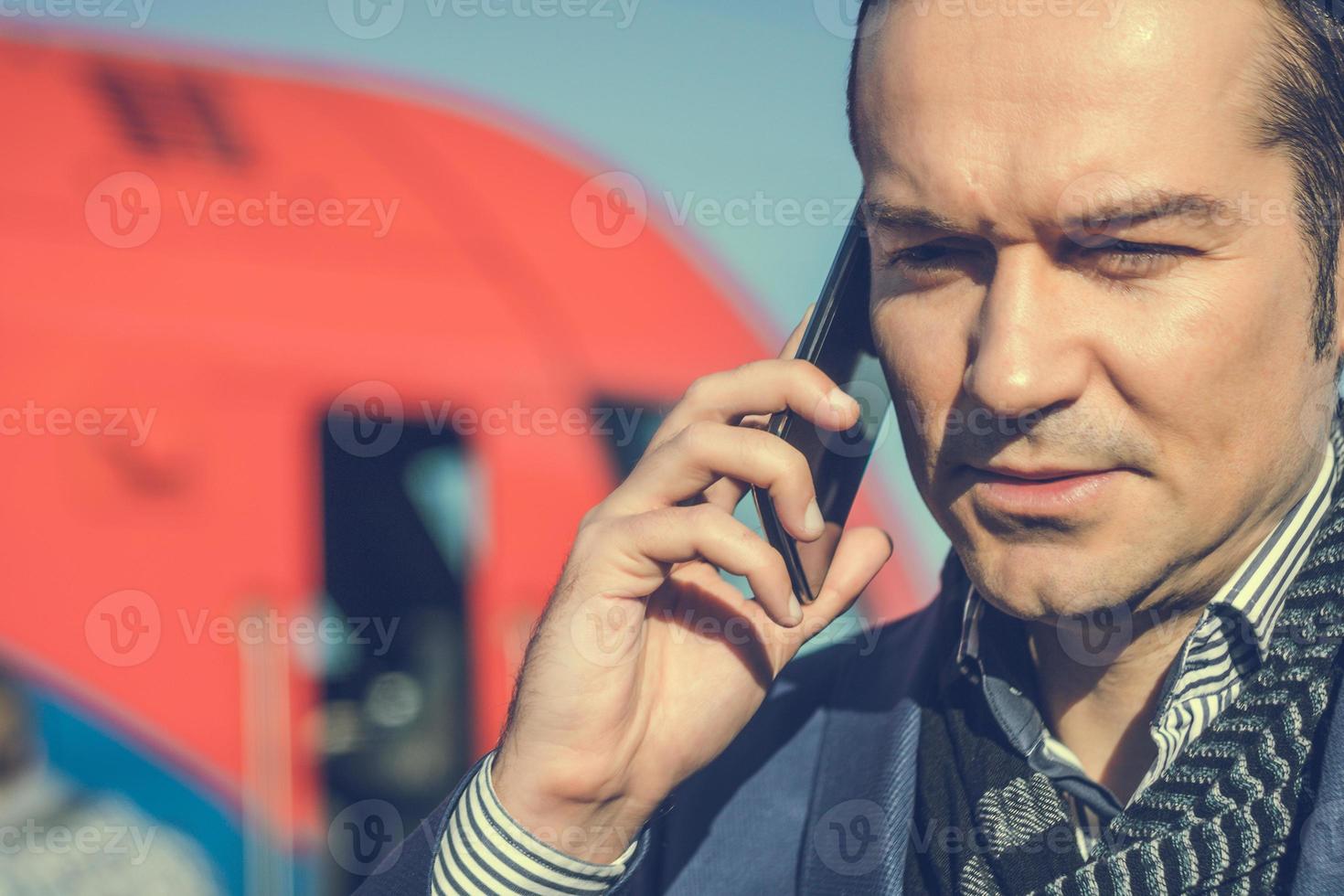 gros plan d'un homme parlant sur un téléphone portable à la gare. photo