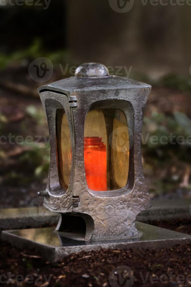 lanterne funéraire dans un cimetière au crépuscule avec une bougie allumée photo