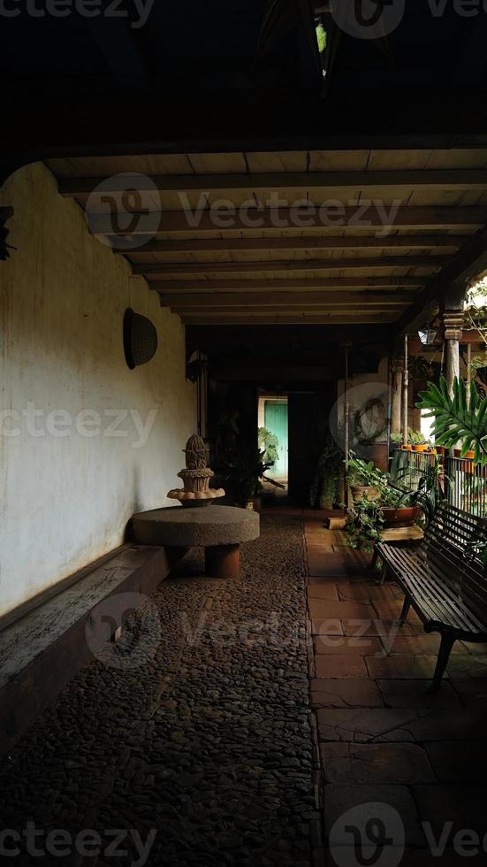 roue de pierre parmi les pots et les plantes, dans une vieille maison au mexique amérique latine photo