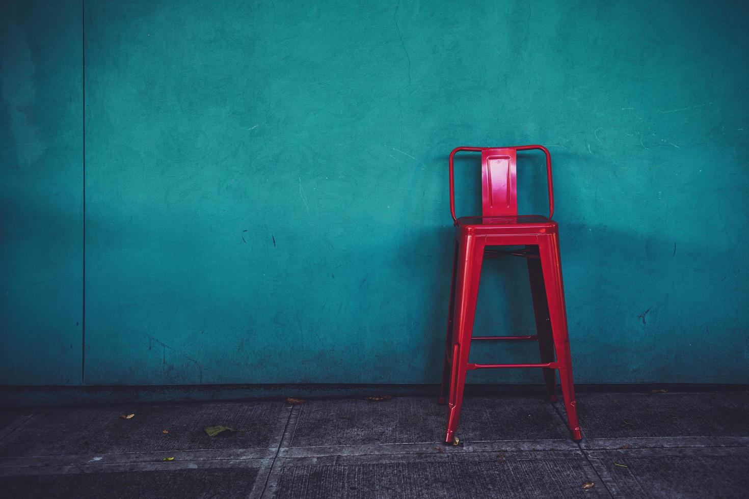 Chaise en métal rouge contre le mur bleu photo