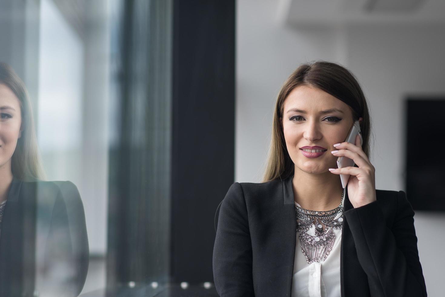 fille d'affaires debout dans un immeuble moderne près de la fenêtre avec téléphone photo