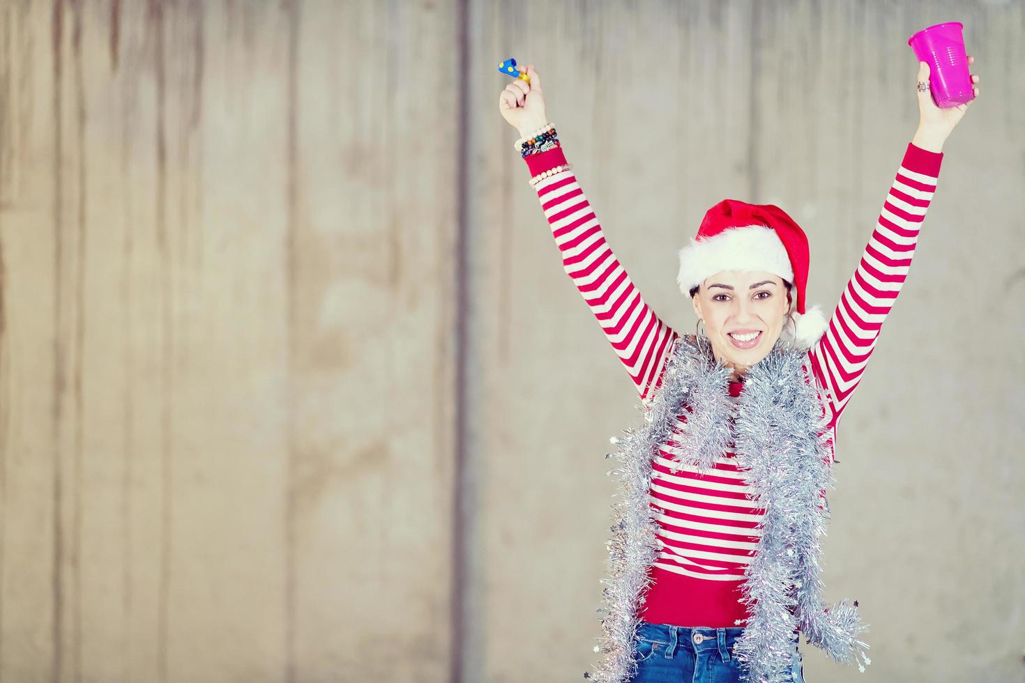 jeune femme d'affaires portant un chapeau rouge et soufflant un sifflet de fête photo