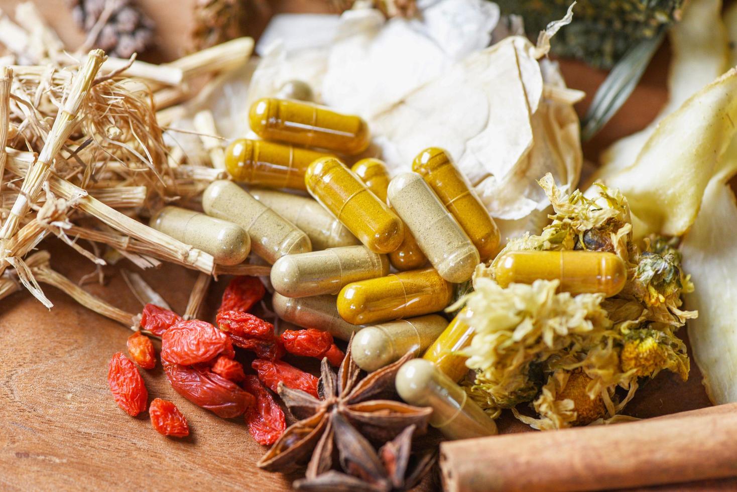 capsules de phytothérapie et herbe séchée de la nature produit biologique non toxique sur fond de bois - épices et herbes sèches ingrédients alimentaires en thaïlande asiatique pour un mode de vie sain photo