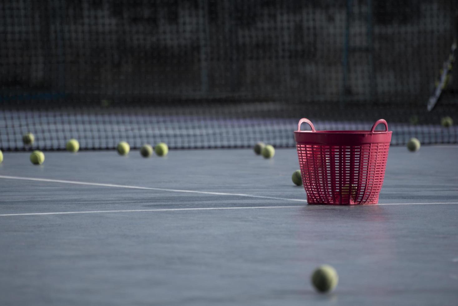 un panier de tennis rouge sur le court photo