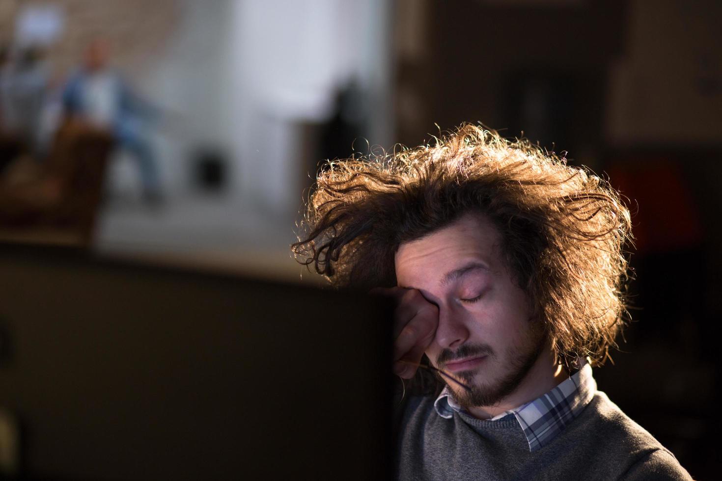 homme travaillant sur ordinateur dans un bureau sombre photo