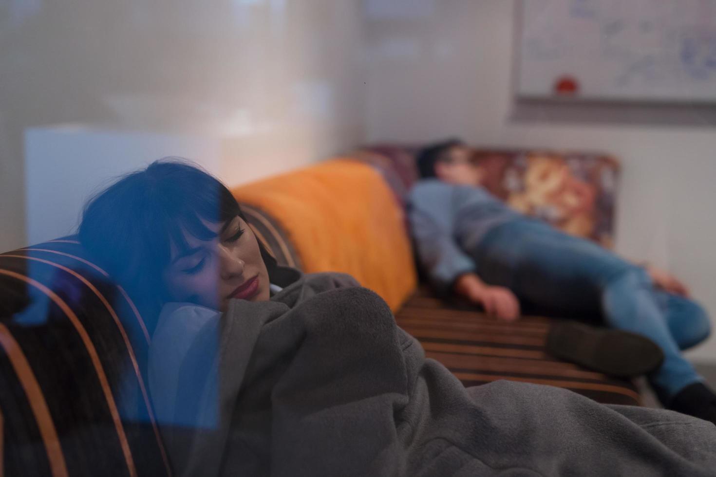 développeurs de logiciels dormant sur un canapé dans un bureau de démarrage créatif photo