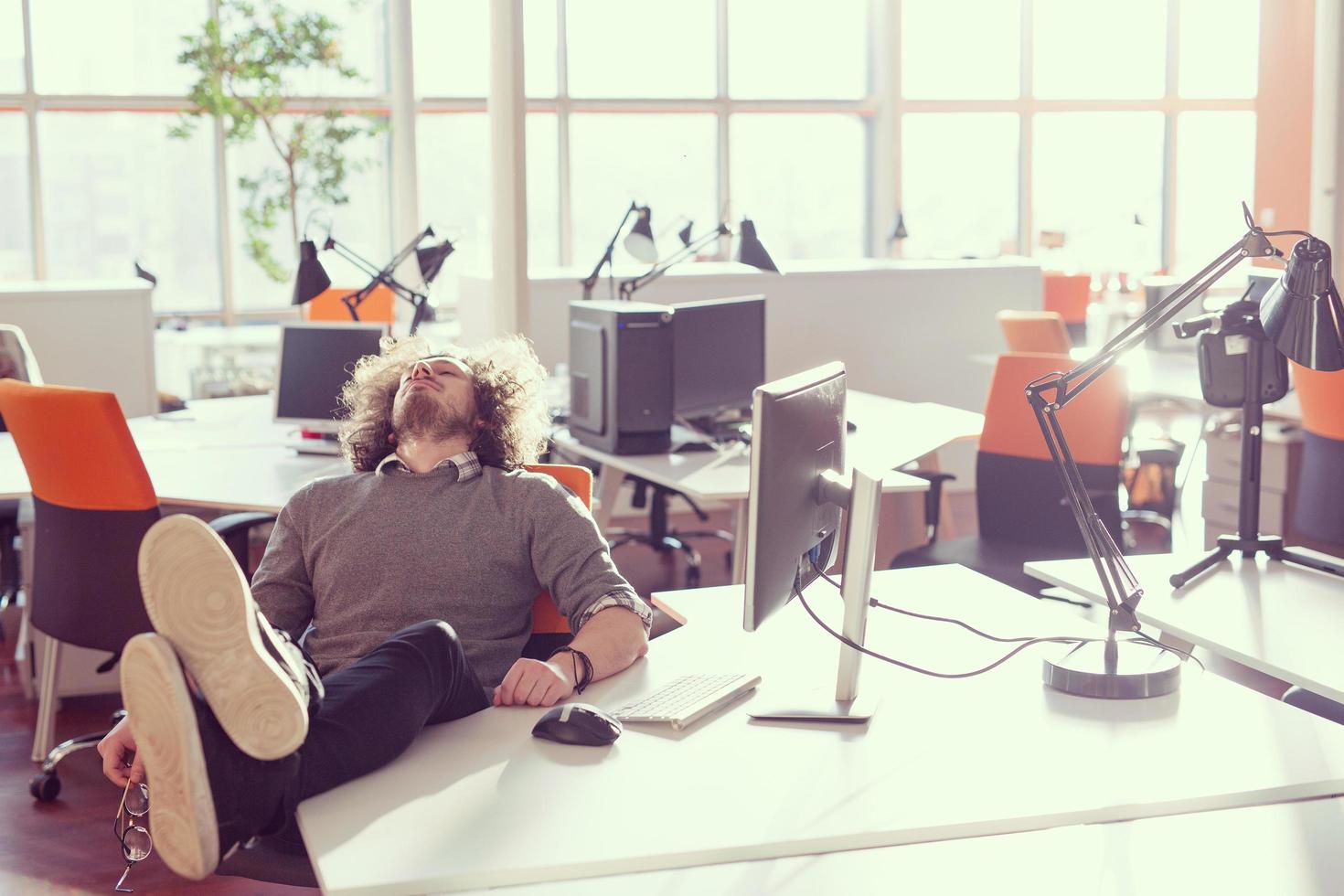 homme d'affaires assis avec les jambes sur le bureau photo