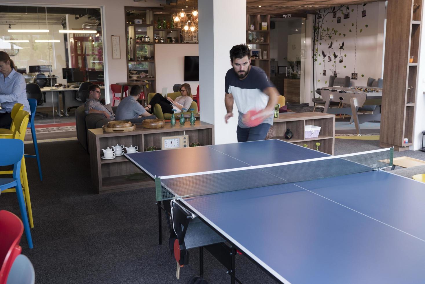jouer au tennis de ping-pong dans un espace de bureau créatif photo