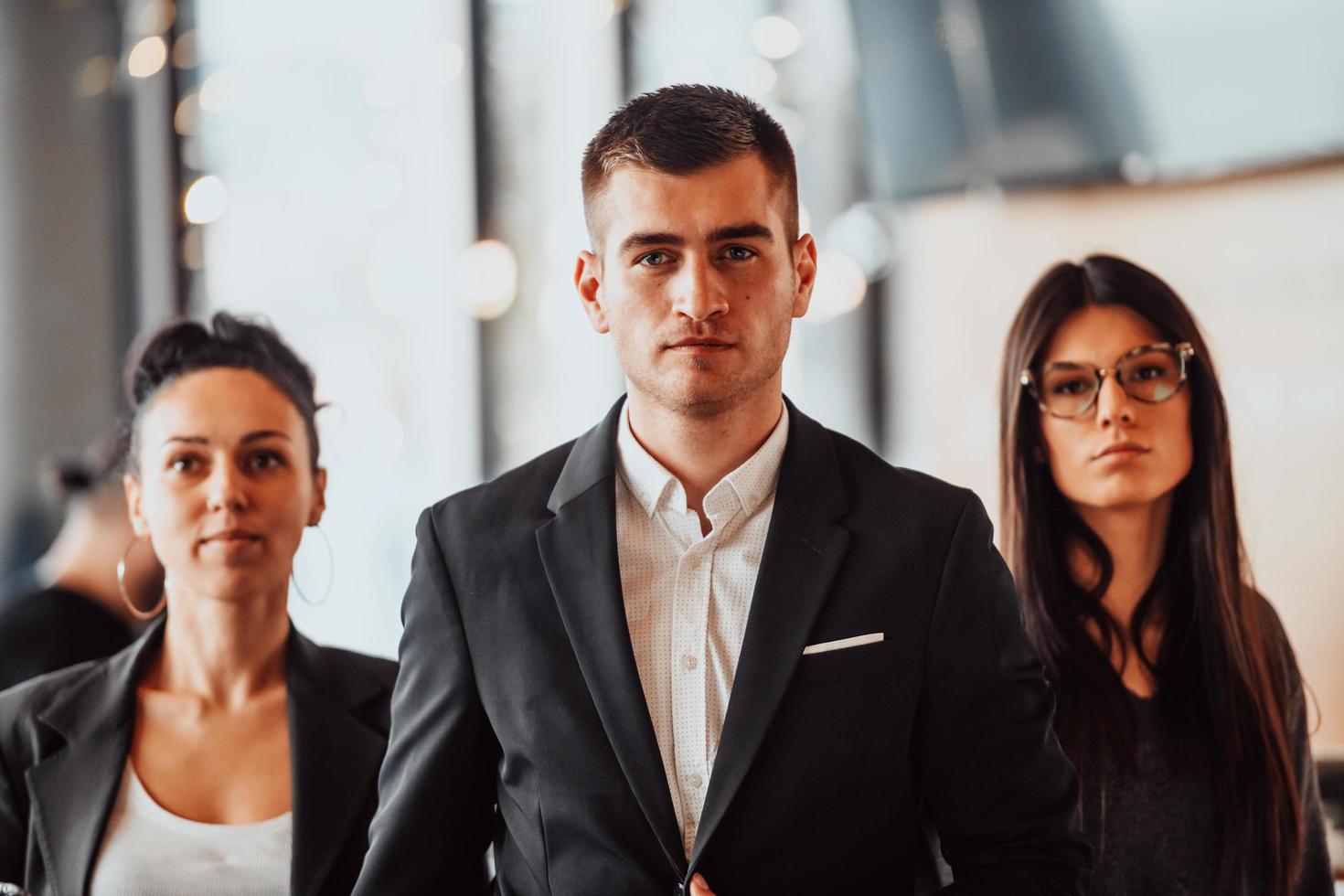 groupe de gens d'affaires prospères se tenant ensemble au bureau de coworking moderne. photo