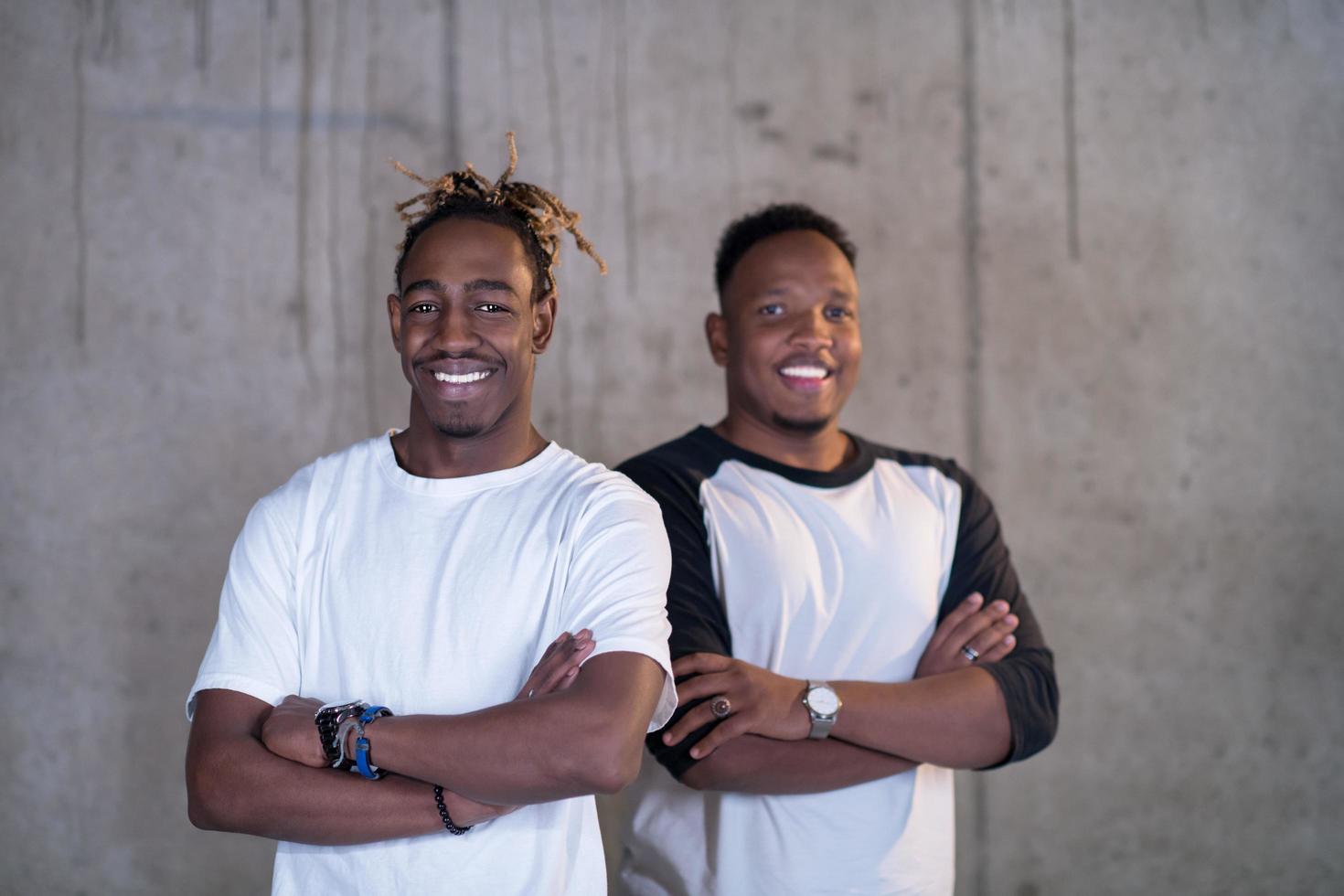 portrait de deux hommes d'affaires noirs devant un mur de béton photo