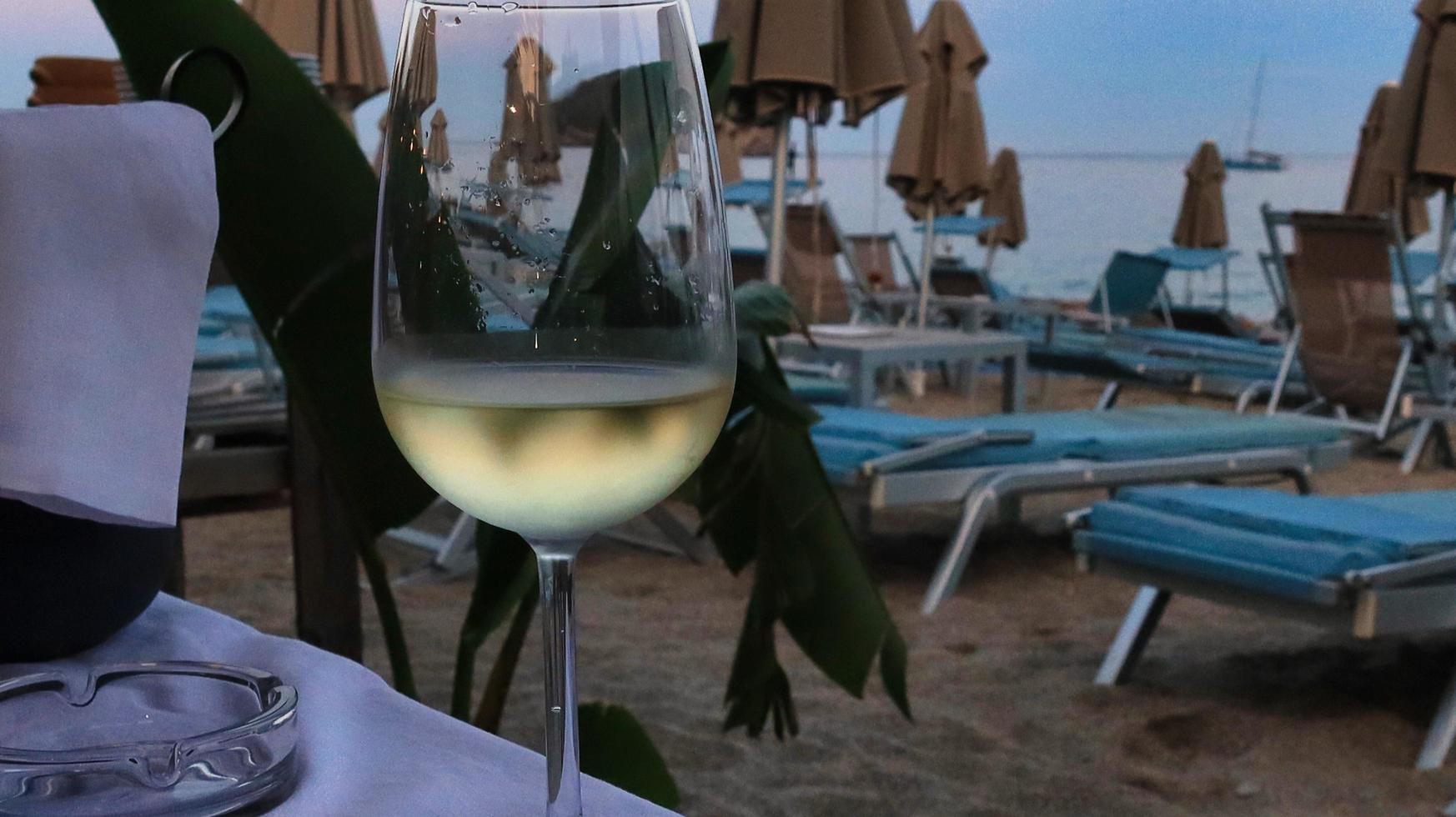 un verre de vin blanc frais dans un restaurant en bord de mer durant l'été 2022 photo