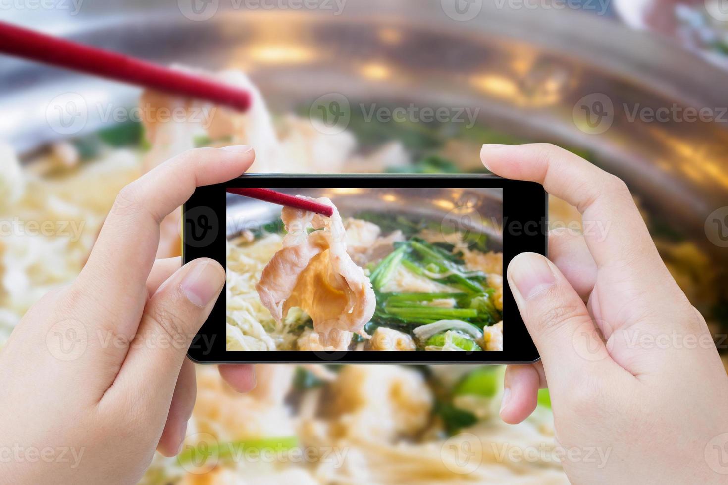 femme prenant une photo de sukiyaki shabu shabu