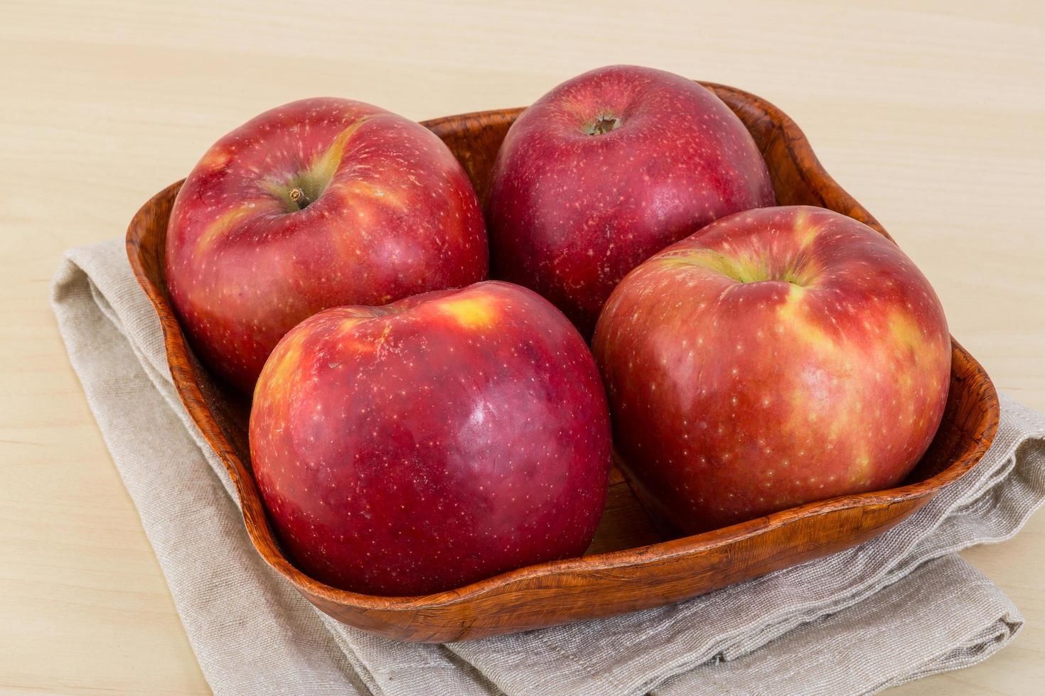 pommes rouges dans un bol sur fond de bois photo