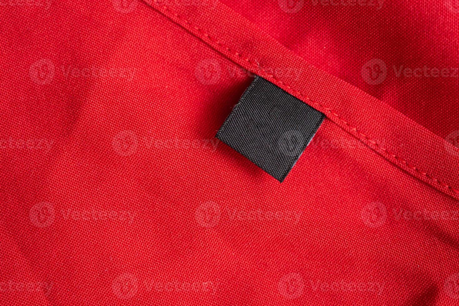 étiquette de vêtements de soin de lessive noire vierge sur la texture de tissu de couleur rouge photo