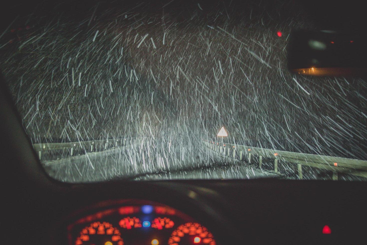 neige et autoroute vu à travers le pare-brise de voiture photo