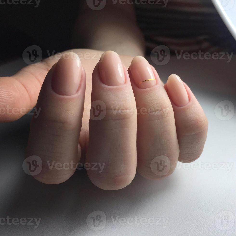 manucure rose féminine à la mode élégante. mains d'une femme avec manucure rose sur les ongles photo