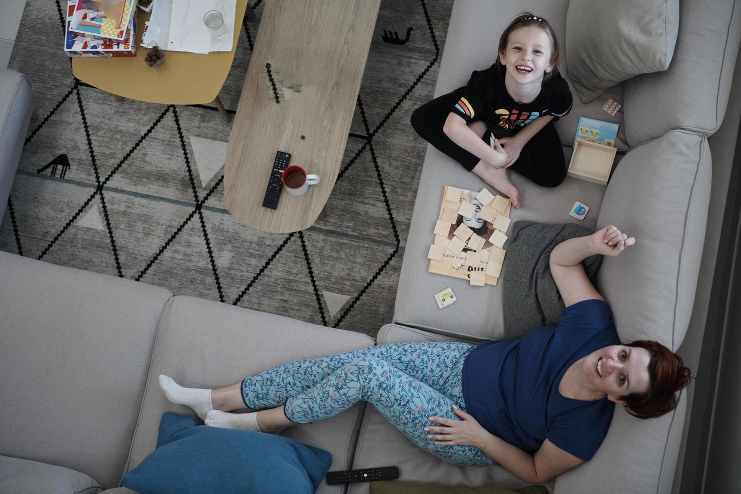 mère et fille à la maison jouant à un jeu de mémoire photo