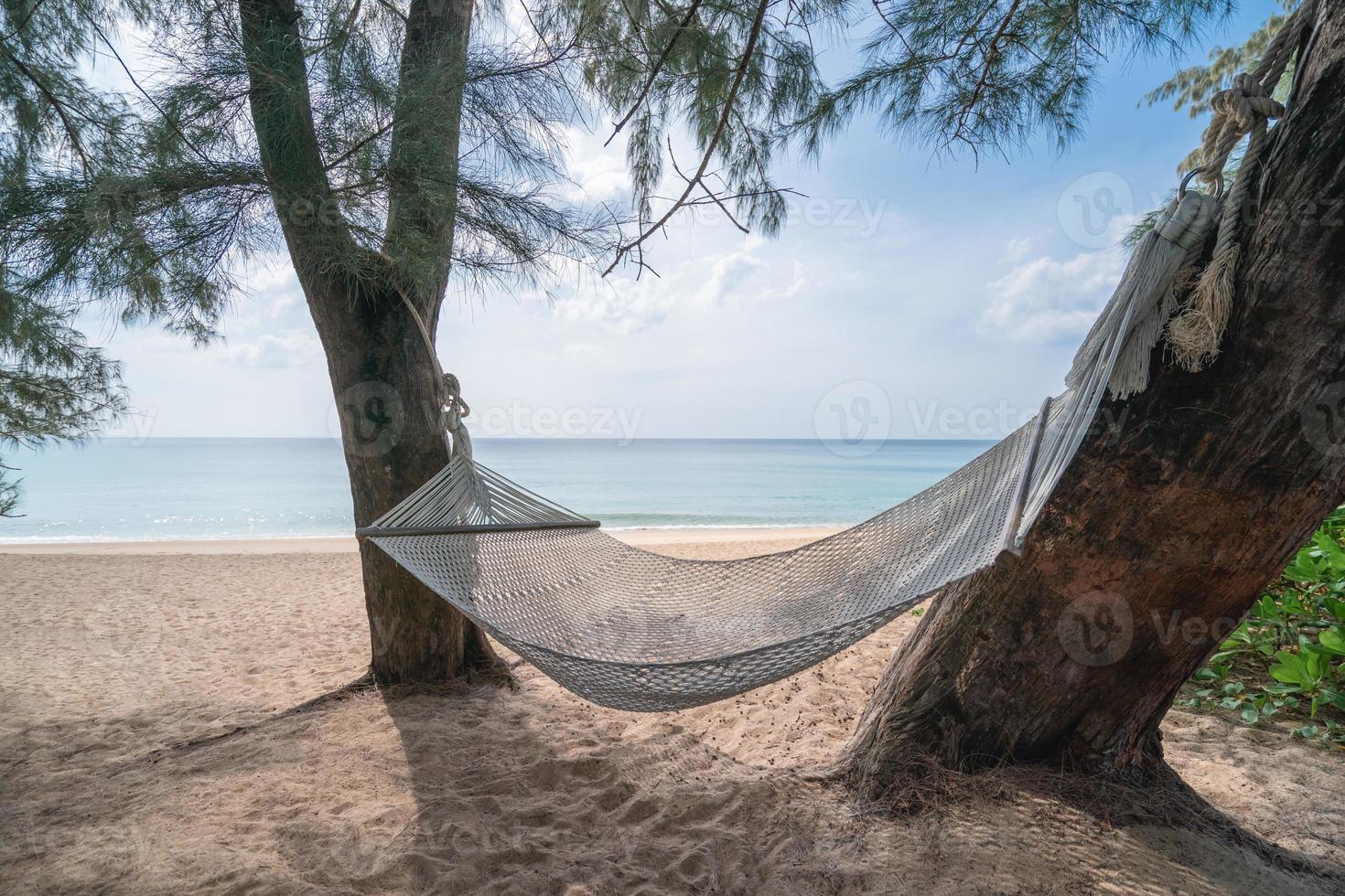balançoire hamac entre les arbres sur une île tropicale avec une belle plage. photo