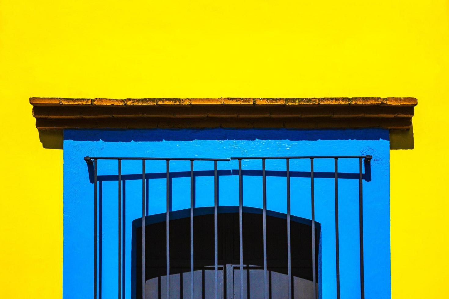 Fenêtre en cage bleue sur mur jaune photo