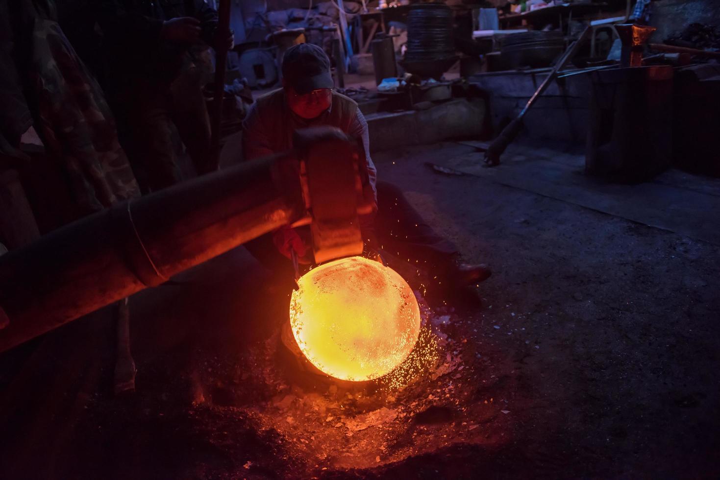 Ouvriers forgerons utilisant un marteau mécanique à l'atelier photo