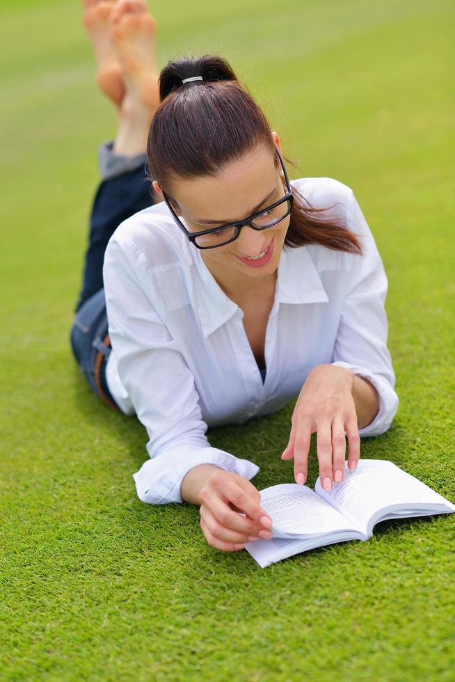 jeune femme lisant un livre dans le parc photo