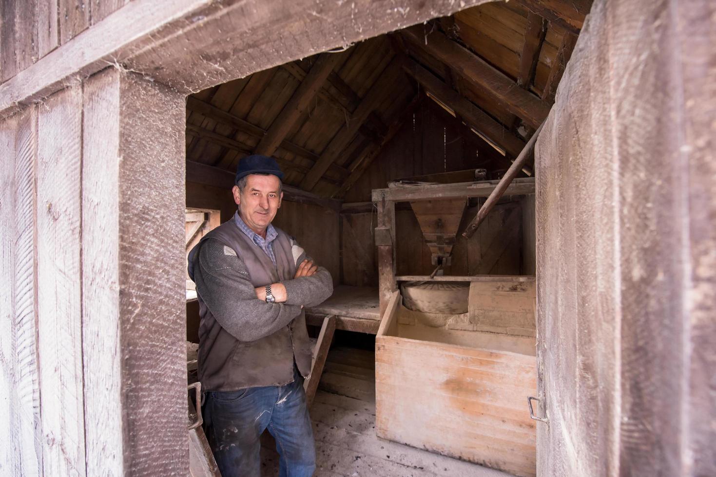 portrait d'un meunier dans un moulin à eau en bois rétro photo