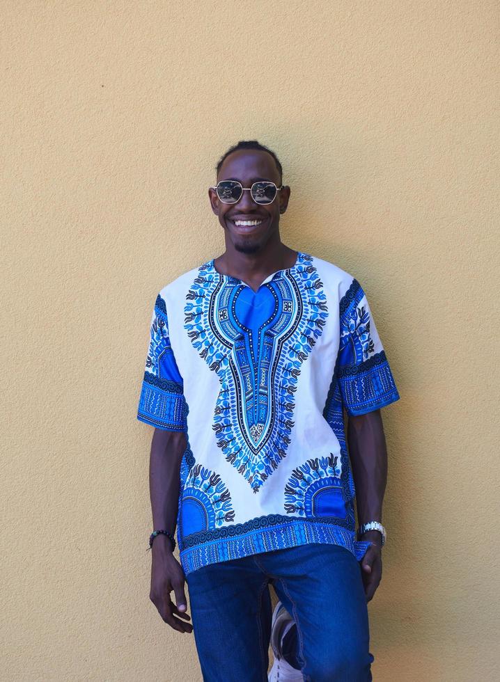 portrait d'un jeune homme africain souriant portant des vêtements traditionnels photo
