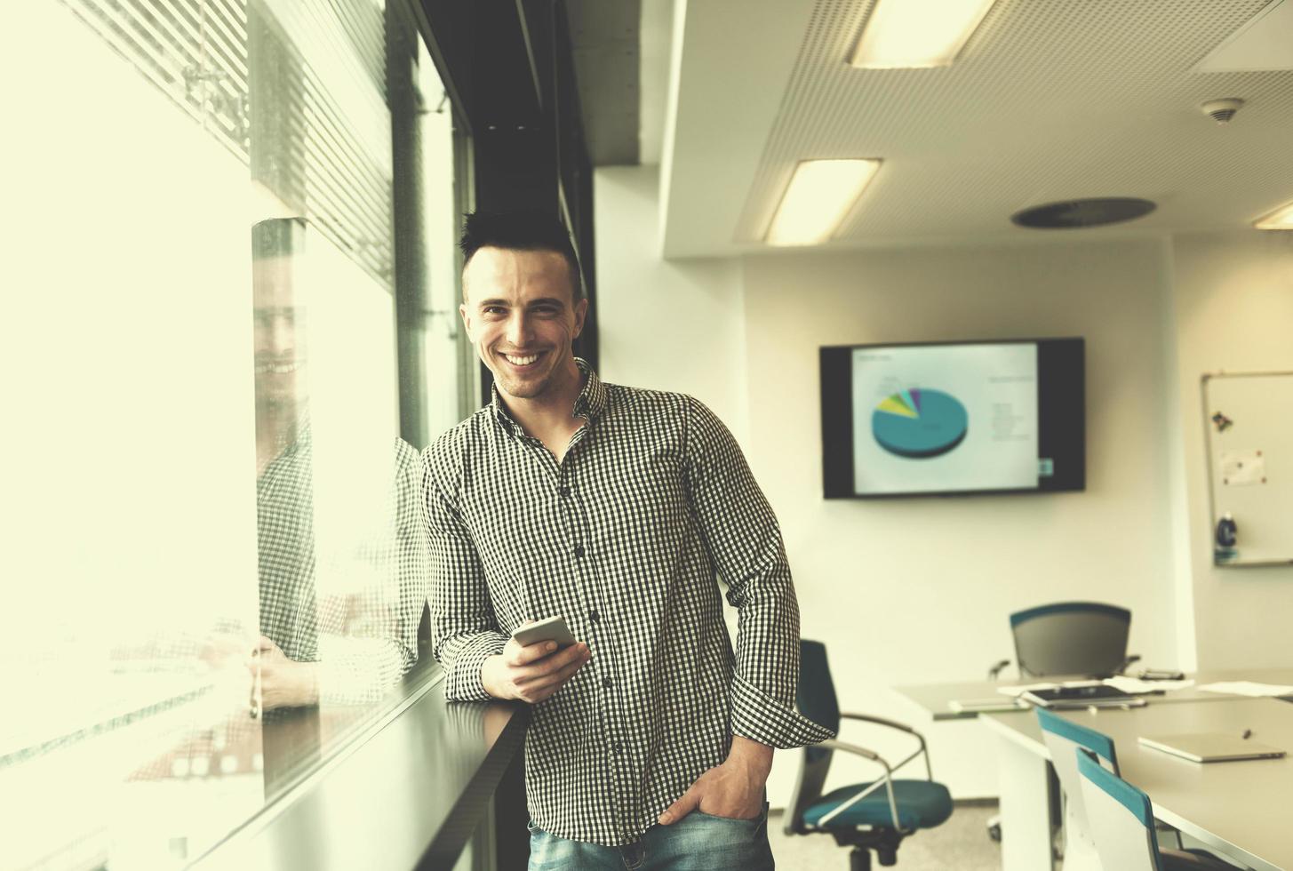 jeune homme d'affaires utilisant un téléphone intelligent au bureau photo