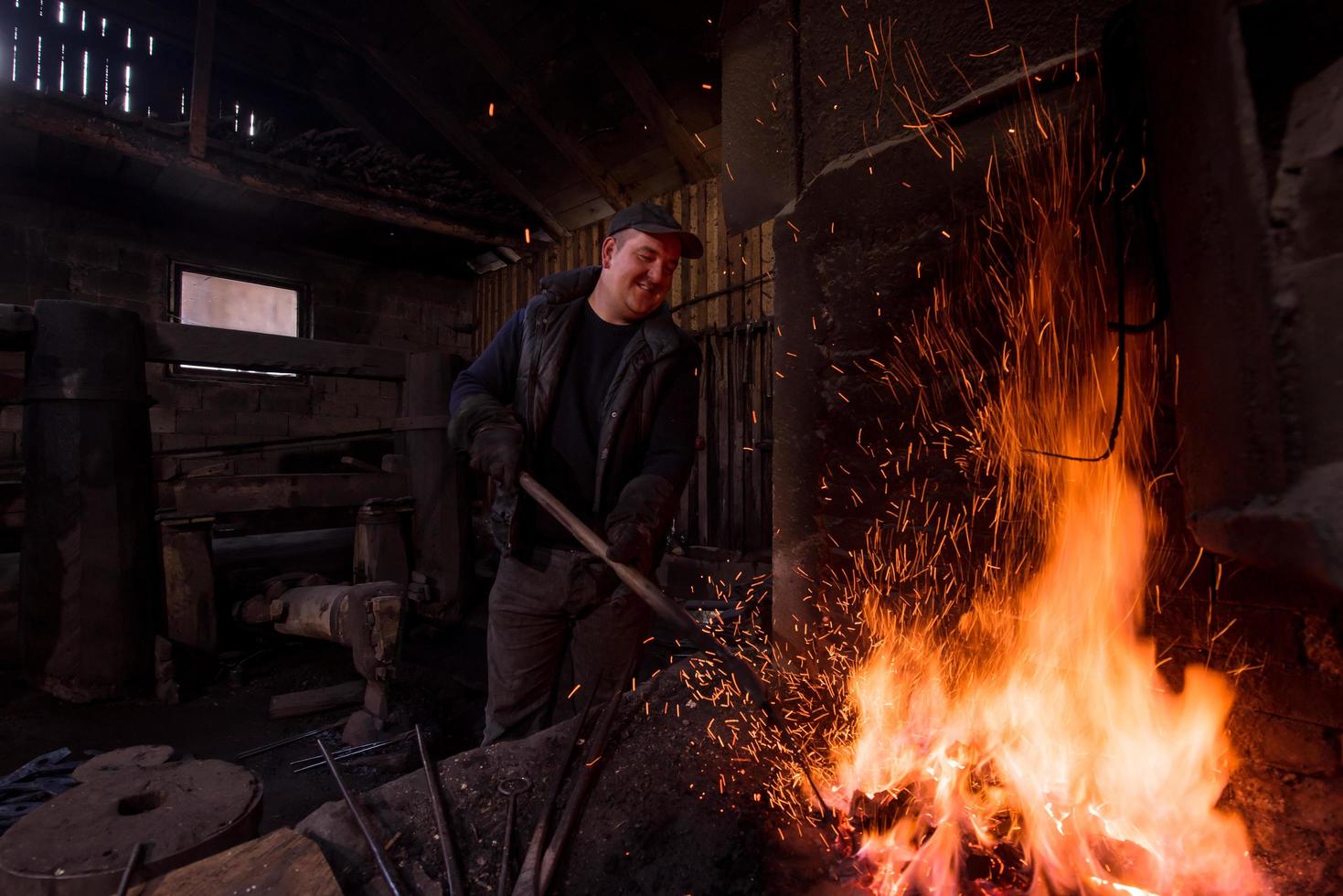 jeune forgeron traditionnel travaillant avec feu ouvert photo