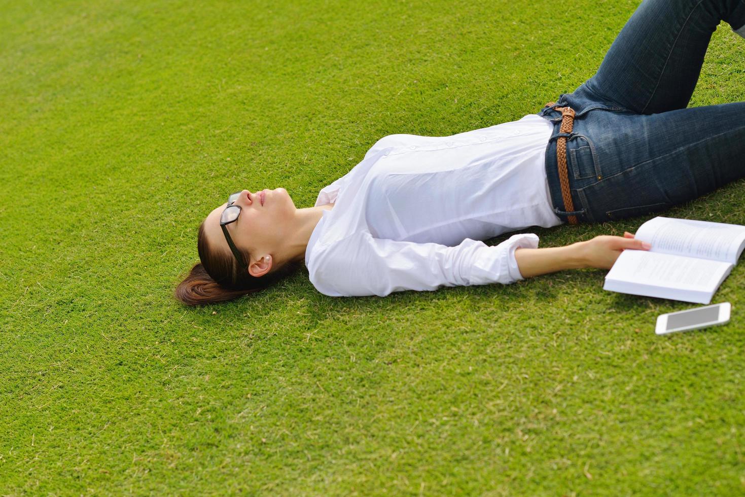 jeune femme lisant un livre dans le parc photo