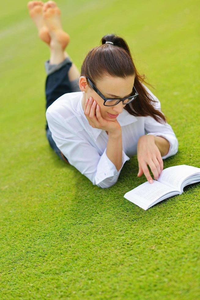 jeune femme lisant un livre dans le parc photo