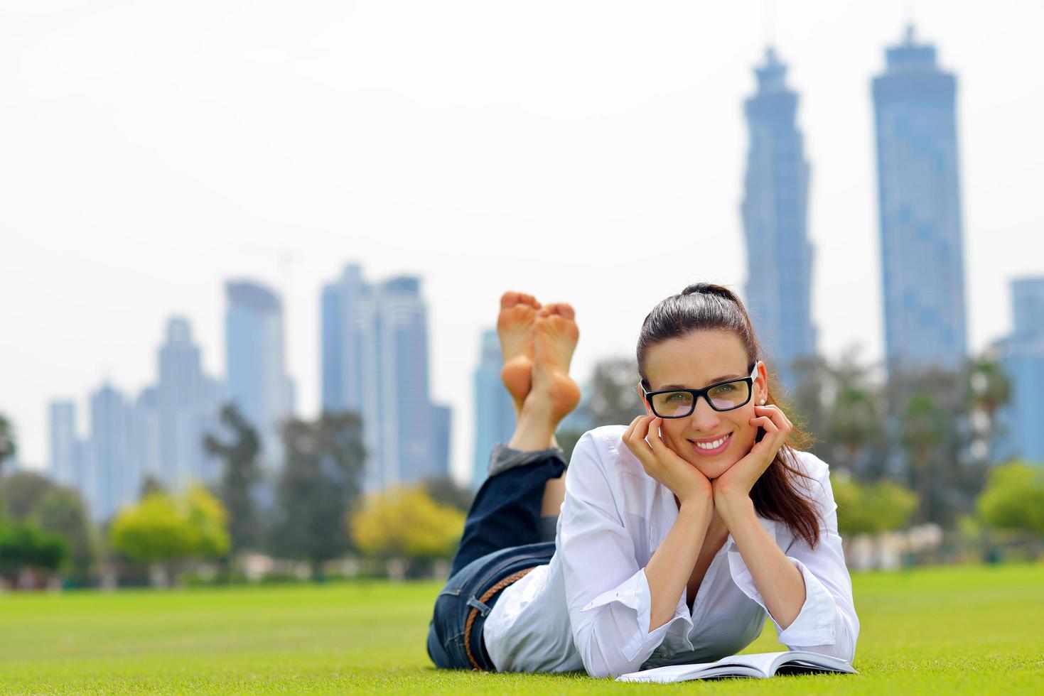 jeune femme lisant un livre dans le parc photo