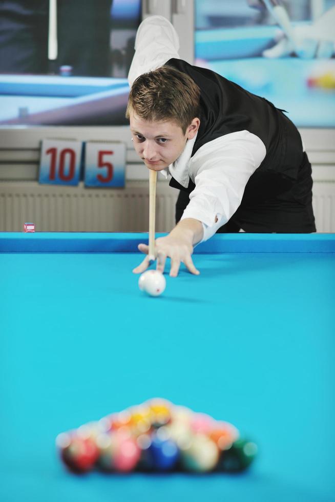 jeune homme joue au jeu de billard pro photo