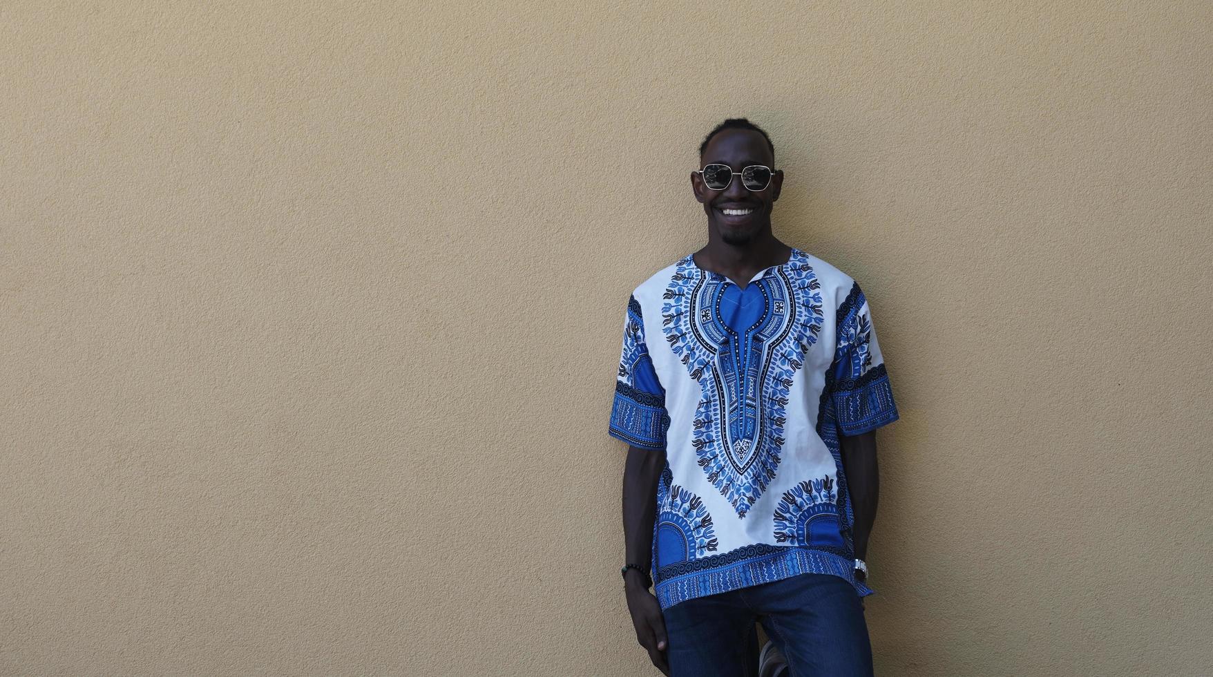 portrait d'un jeune homme africain souriant portant des vêtements traditionnels photo