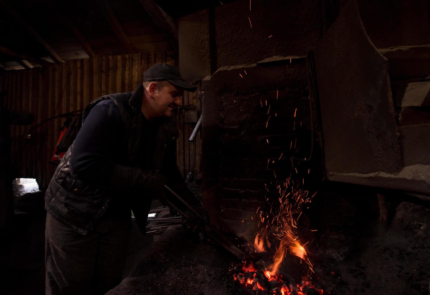 jeune forgeron traditionnel travaillant avec feu ouvert photo