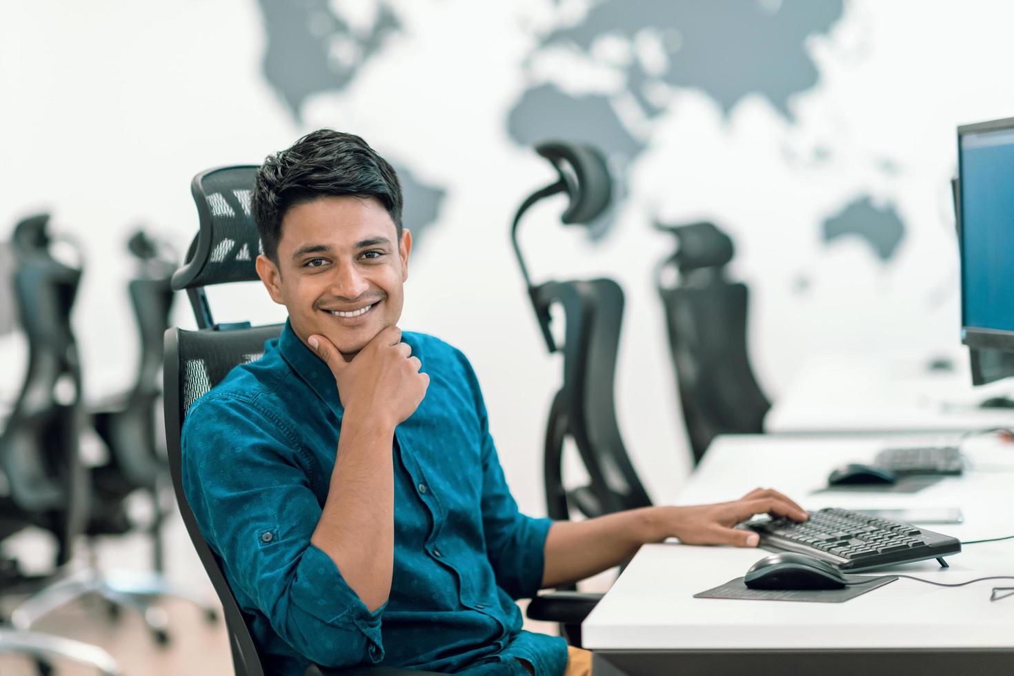 homme d'affaires décontracté travaillant sur un ordinateur de bureau dans un intérieur de bureau de démarrage à plan ouvert moderne. mise au point sélective photo