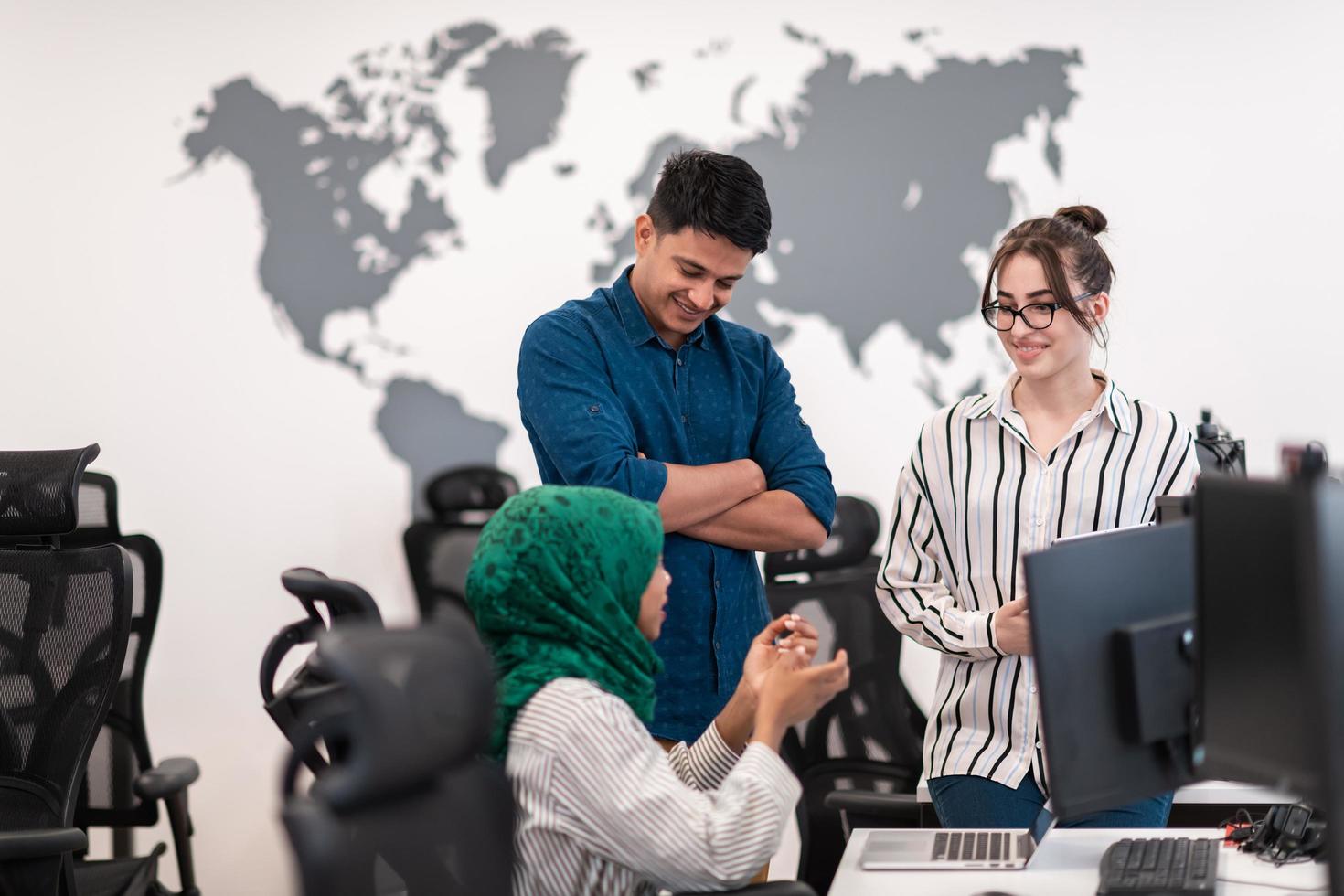 femme de l'équipe d'affaires de démarrage multiethnique portant un hijab lors d'une réunion dans un brainstorming intérieur de bureau ouvert moderne, travaillant sur un ordinateur portable et un ordinateur de bureau. mise au point sélective photo