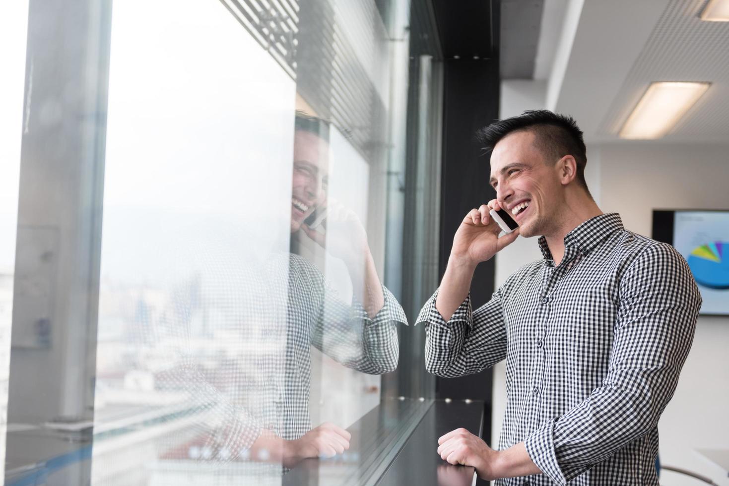 jeune homme d'affaires parlant au téléphone intelligent au bureau photo