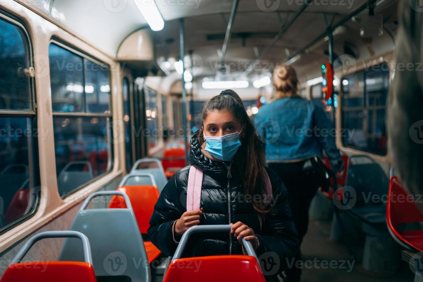 jeune femme avec masque voyageant dans les transports en commun. photo