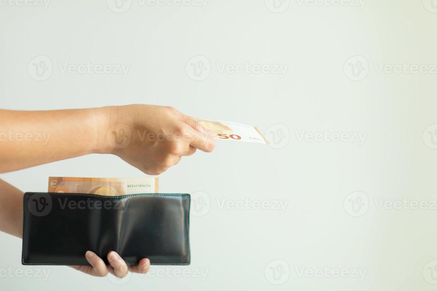 une main prenant un billet de banque dans le portefeuille court et payant en euros. photo