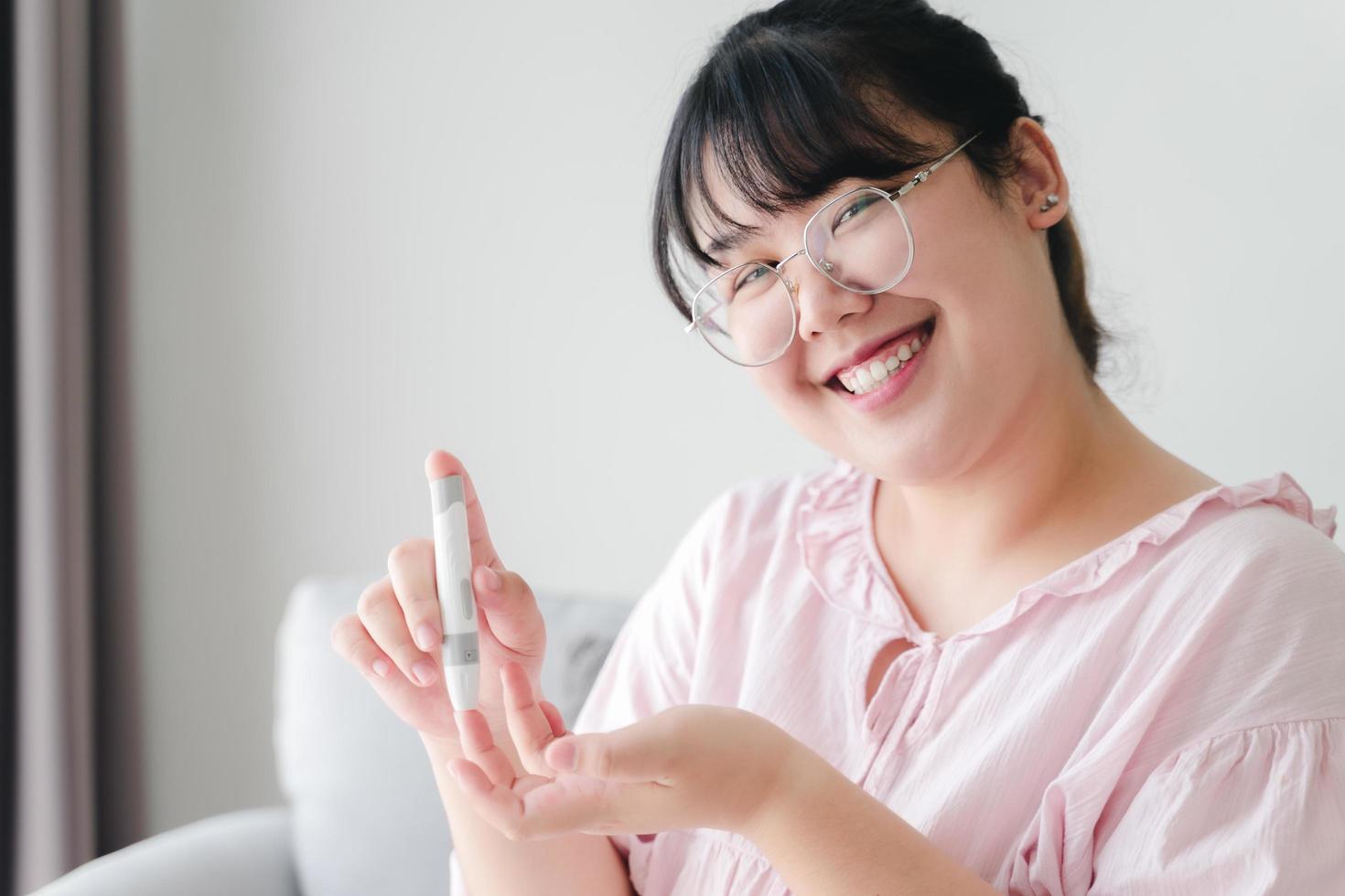 femme asiatique utilisant une lancette sur le doigt pour vérifier la glycémie par glucomètre, soins de santé et médecine, diabète, concept de glycémie photo