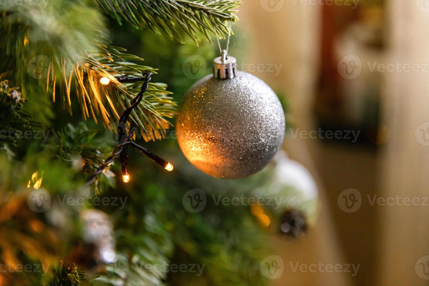 arbre de nouvel an décoré de noël classique. sapin de noël avec décorations blanches et argentées, jouet d'ornements et balle. appartement de design d'intérieur de style classique moderne. réveillon de noël à la maison. photo