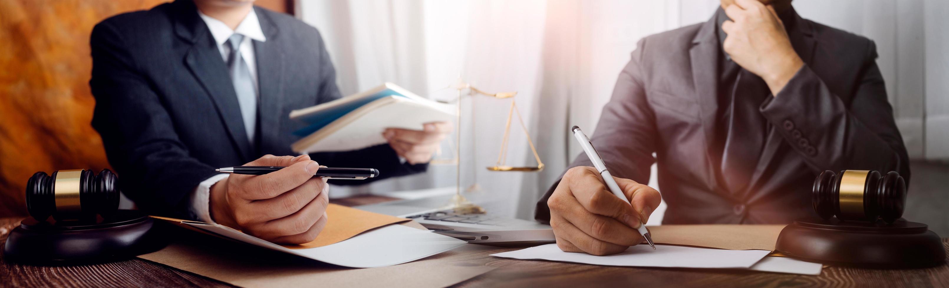 concept de justice et de droit. juge masculin dans une salle d'audience sur une table en bois et conseiller ou avocat masculin travaillant au bureau. concept de droit, de conseil et de justice juridique. photo