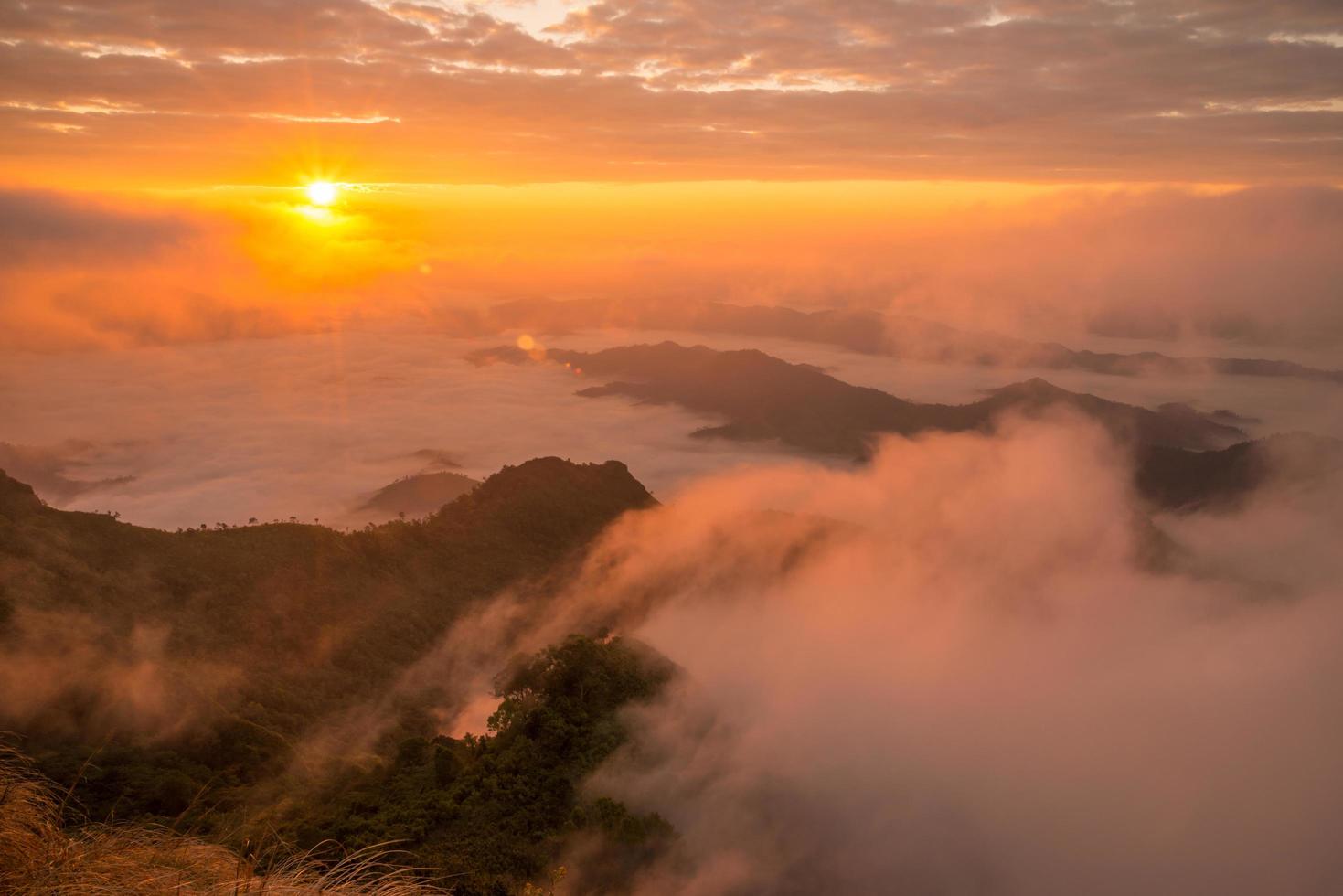 le beau lever de soleil sur le paysage de la brume marine couvre les montagnes des hautes terres nommées phu chi dao situées dans la province de chiang rai dans la région nord de la thaïlande. photo