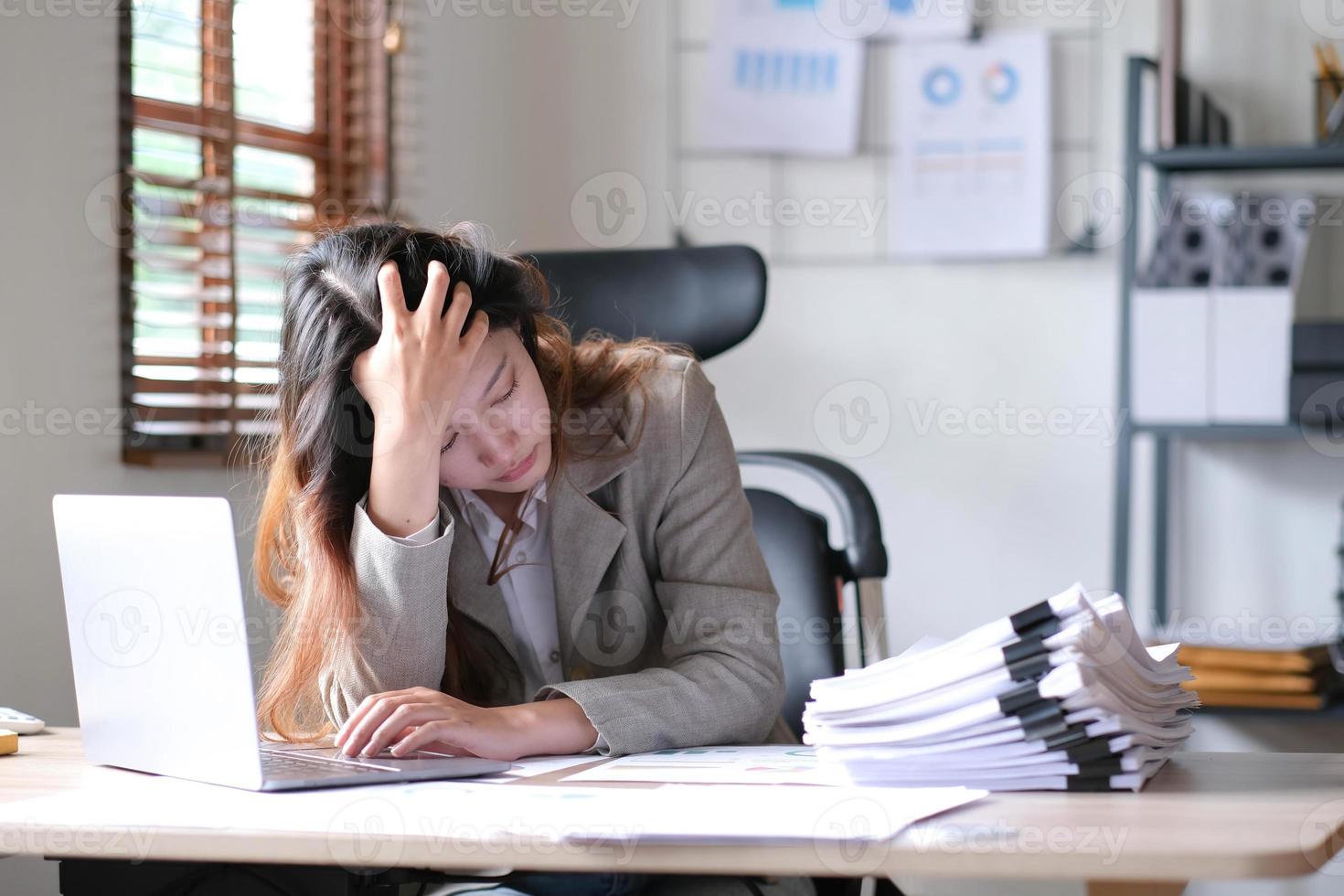 une femme d'affaires asiatique est stressée tout en ayant un problème au travail au bureau. photo